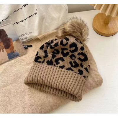 Тепла вязана шапка з леопардовим принтом та помпоном