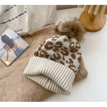 Тепла вязана шапка з леопардовим принтом та помпоном
